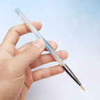 One hand holding a paintbrush
