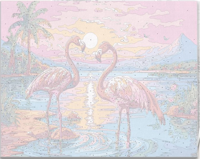 A pair of pink flamingos stand close together on the edge of a body of water at sunset or sunrise, with colorful sky and warm hues reflecting off the calm surface of the water.